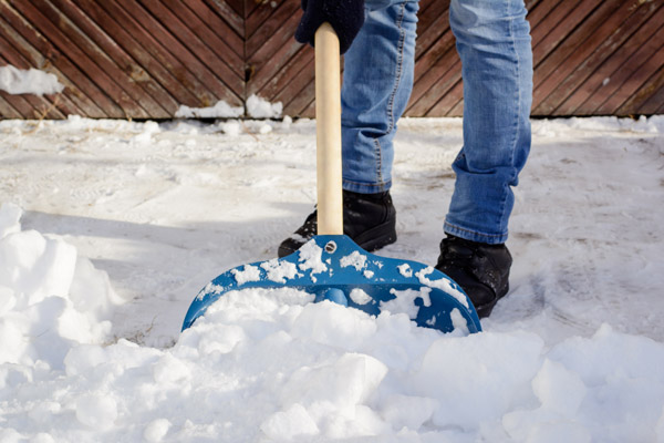 Young Man Shoveling Snow In The Driveway