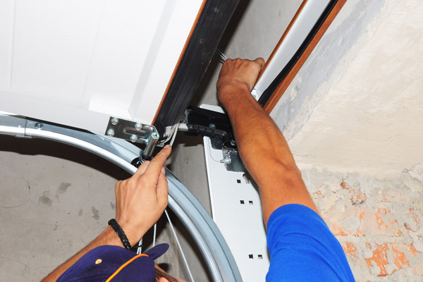 garage door technicians replacing faulty garage door spring/torsion spring